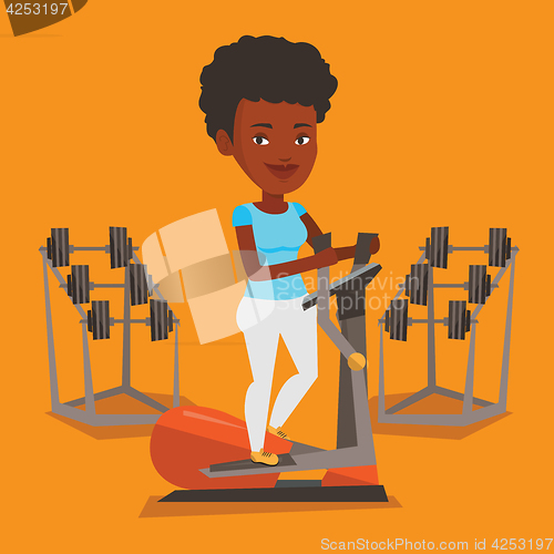Image of Woman exercising on elliptical trainer.