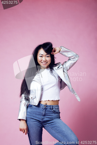 Image of young pretty smiling asian korean girl wearing modern fashion clothers on pink background, lifestyle people concept