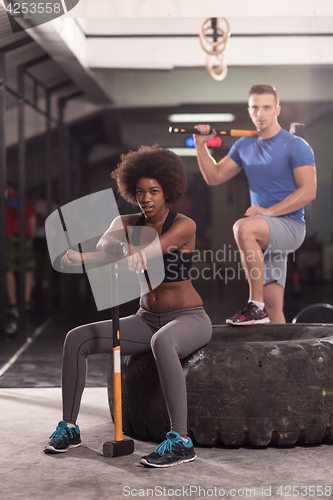 Image of multiethnic couple after workout with hammer