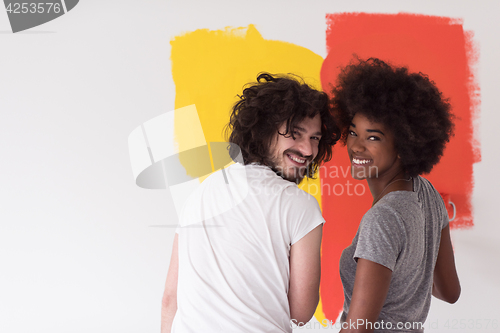 Image of multiethnic couple painting interior wall