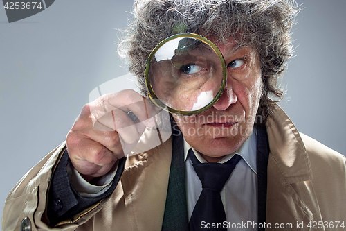 Image of The senior man as detective or boss of mafia on gray studio background