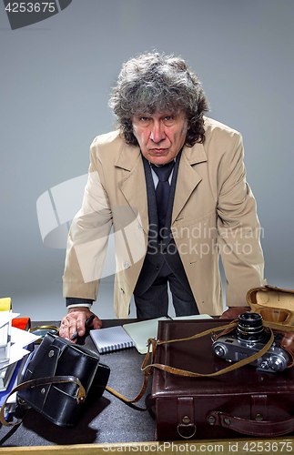 Image of The senior man as detective or boss of mafia on gray studio background