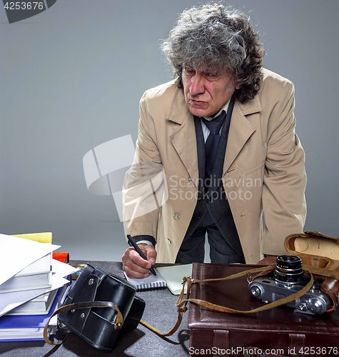 Image of The senior man as detective or boss of mafia on gray studio background