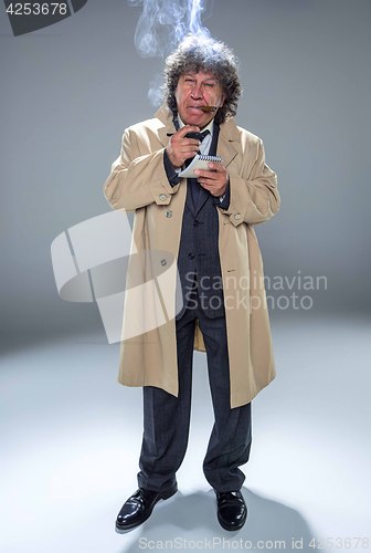 Image of The senior man as detective or boss of mafia on gray studio background