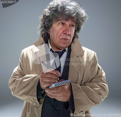 Image of The senior man as detective or boss of mafia on gray studio background