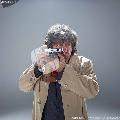 Image of The senior man as detective or boss of mafia on gray studio background