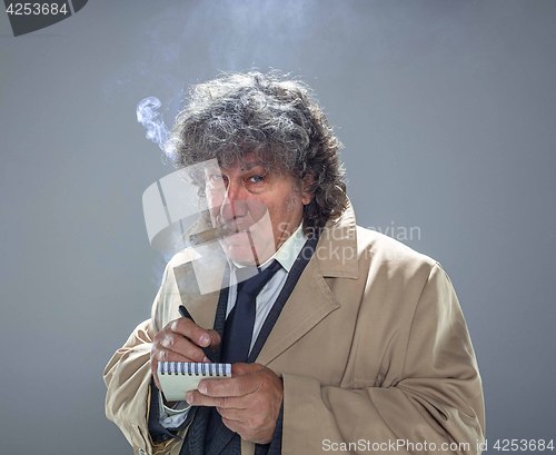 Image of The senior man as detective or boss of mafia on gray studio background