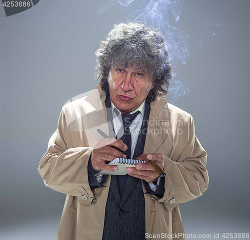 Image of The senior man as detective or boss of mafia on gray studio background