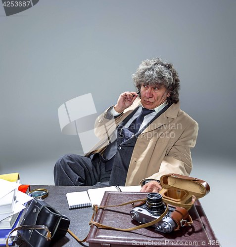 Image of The senior man as detective or boss of mafia on gray studio background