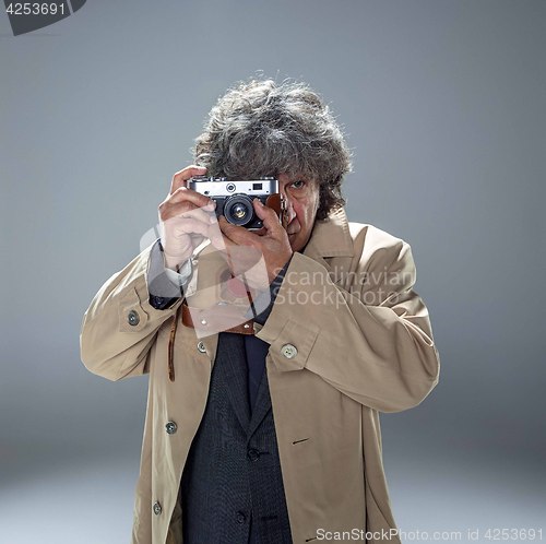 Image of The senior man as detective or boss of mafia on gray studio background