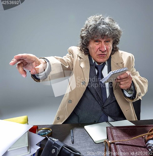 Image of The senior man as detective or boss of mafia on gray studio background