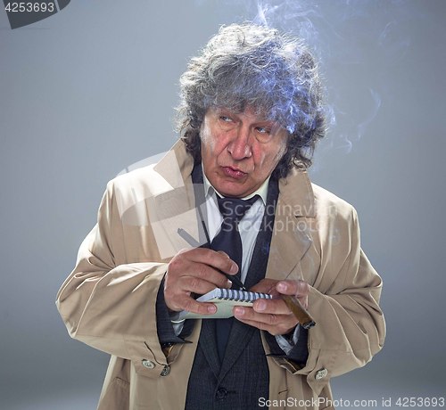 Image of The senior man as detective or boss of mafia on gray studio background