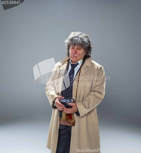 Image of The senior man as detective or boss of mafia on gray studio background