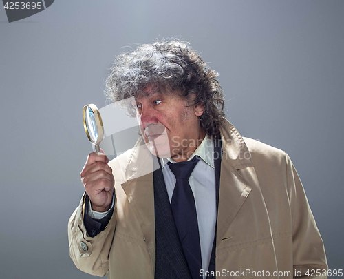 Image of The senior man as detective or boss of mafia on gray studio background