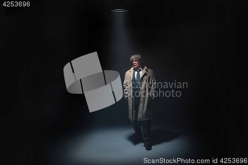 Image of The senior man as detective or boss of mafia on gray studio background