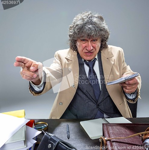 Image of The senior man as detective or boss of mafia on gray studio background