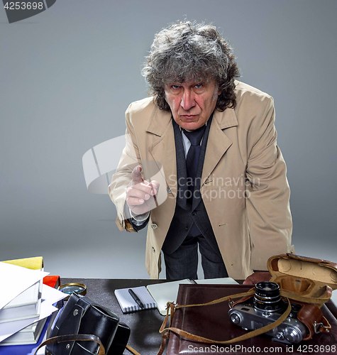 Image of The senior man as detective or boss of mafia on gray studio background