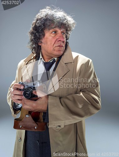 Image of The senior man as detective or boss of mafia on gray studio background