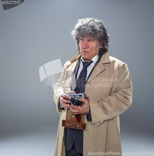 Image of The senior man as detective or boss of mafia on gray studio background