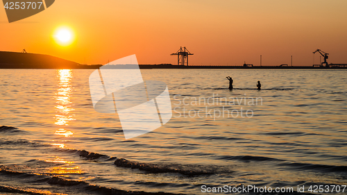 Image of Couple bathing at sunset in the sea