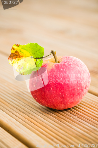 Image of Ripe red apple with a leaf, close-up