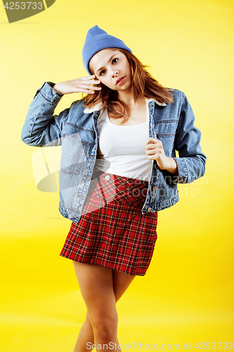 Image of lifestyle people concept: pretty young school teenage girl having fun happy smiling on yellow background
