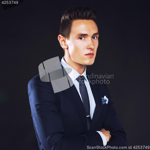 Image of young pretty business man standing on black background, modern h