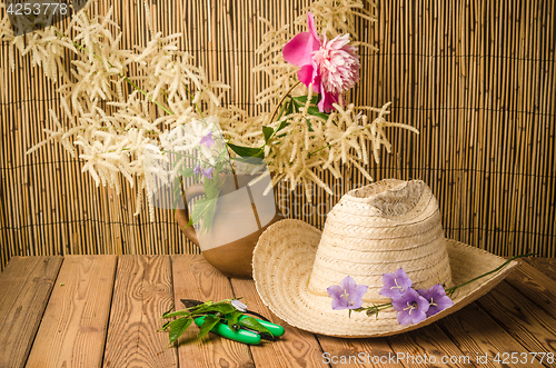Image of Straw hat and flowering campanula, close-up