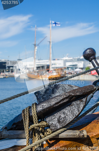 Image of Old rusty anchor at a board of the old sailboat 