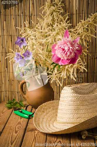 Image of Straw hat and peony flower, close-up