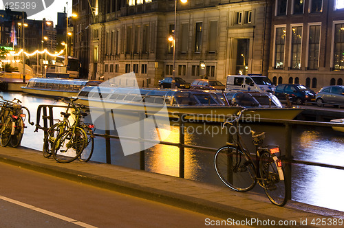 Image of boats on the canal with bicycles night amsterdam holland