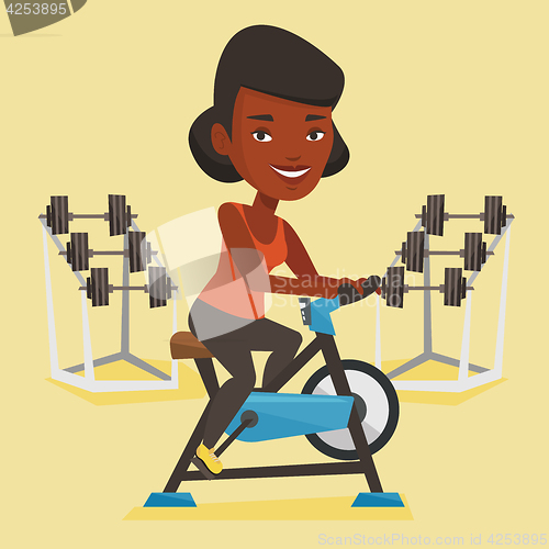 Image of Young woman riding stationary bicycle.