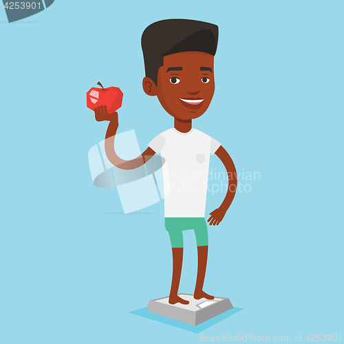 Image of Man standing on scale and holding apple in hand.