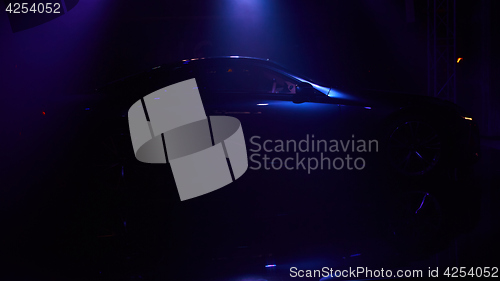 Image of Silhouette of car with headlights on black background.