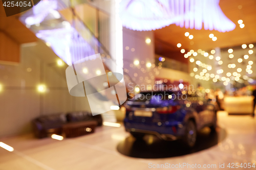 Image of Blurred, defocused background of public event exhibition hall showing cars and automobiles