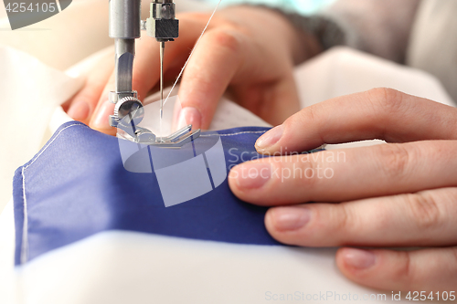 Image of Sewing underwear. Woman sewing on the sewing machine