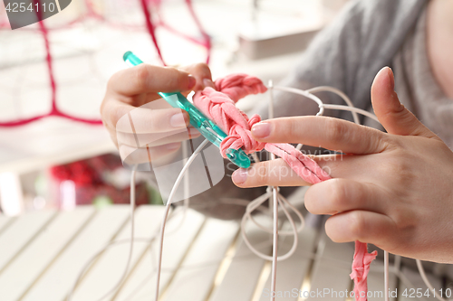 Image of Needlework. Handicraft. Knitting crochet. The woman knits crochet.