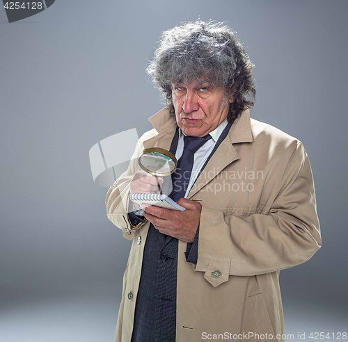 Image of The senior man as detective or boss of mafia on gray studio background