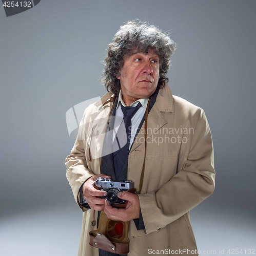 Image of The senior man as detective or boss of mafia on gray studio background