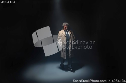 Image of The senior man as detective or boss of mafia on gray studio background