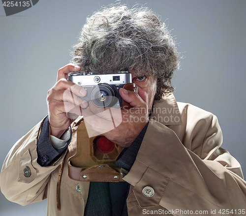 Image of The senior man as detective or boss of mafia on gray studio background