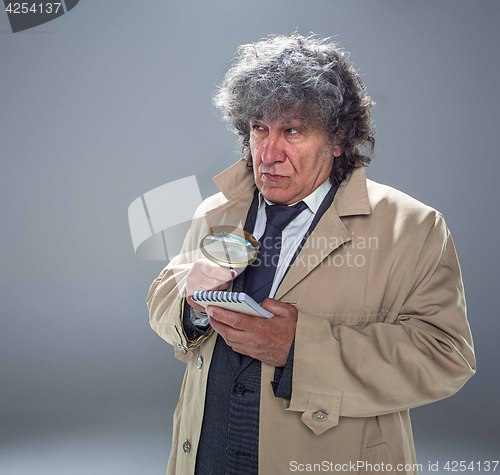 Image of The senior man as detective or boss of mafia on gray studio background