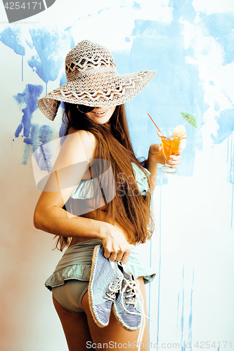 Image of cute bright woman in sunglasses and hat with cocktail in bikini 