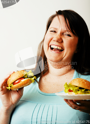 Image of fat white woman having choice between hamburger and salad close 