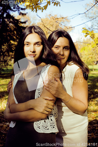 Image of mature real mother with daughter outside autumn fall in park