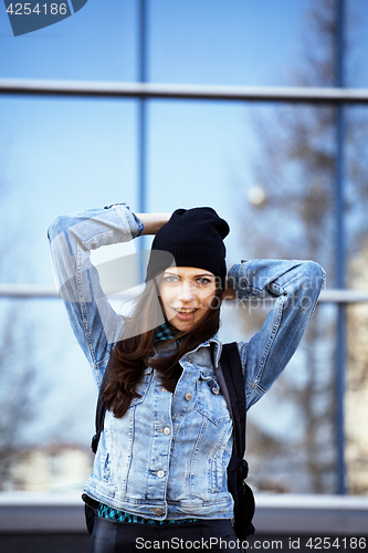 Image of young pretty girl near business building walking