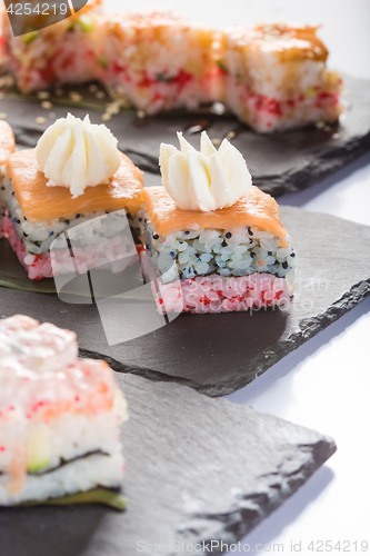 Image of set of sushi on a slate square plate. 