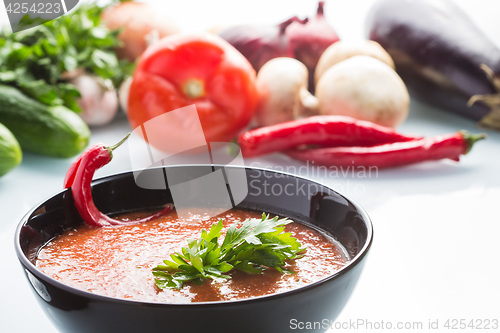 Image of tomato soup in a black plate. 