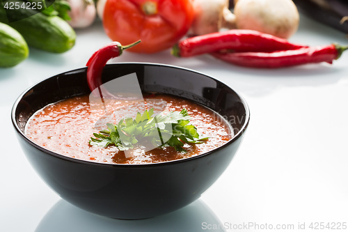 Image of tomato soup in a black plate. 