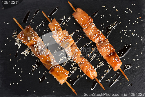 Image of fish kebabs. on a black slate plate.